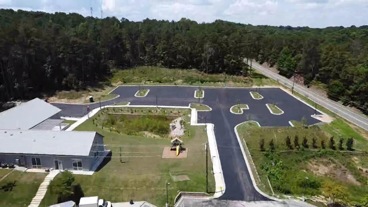 Aerial view of a finished commercial parking lot with landscaped islands and fresh curbing